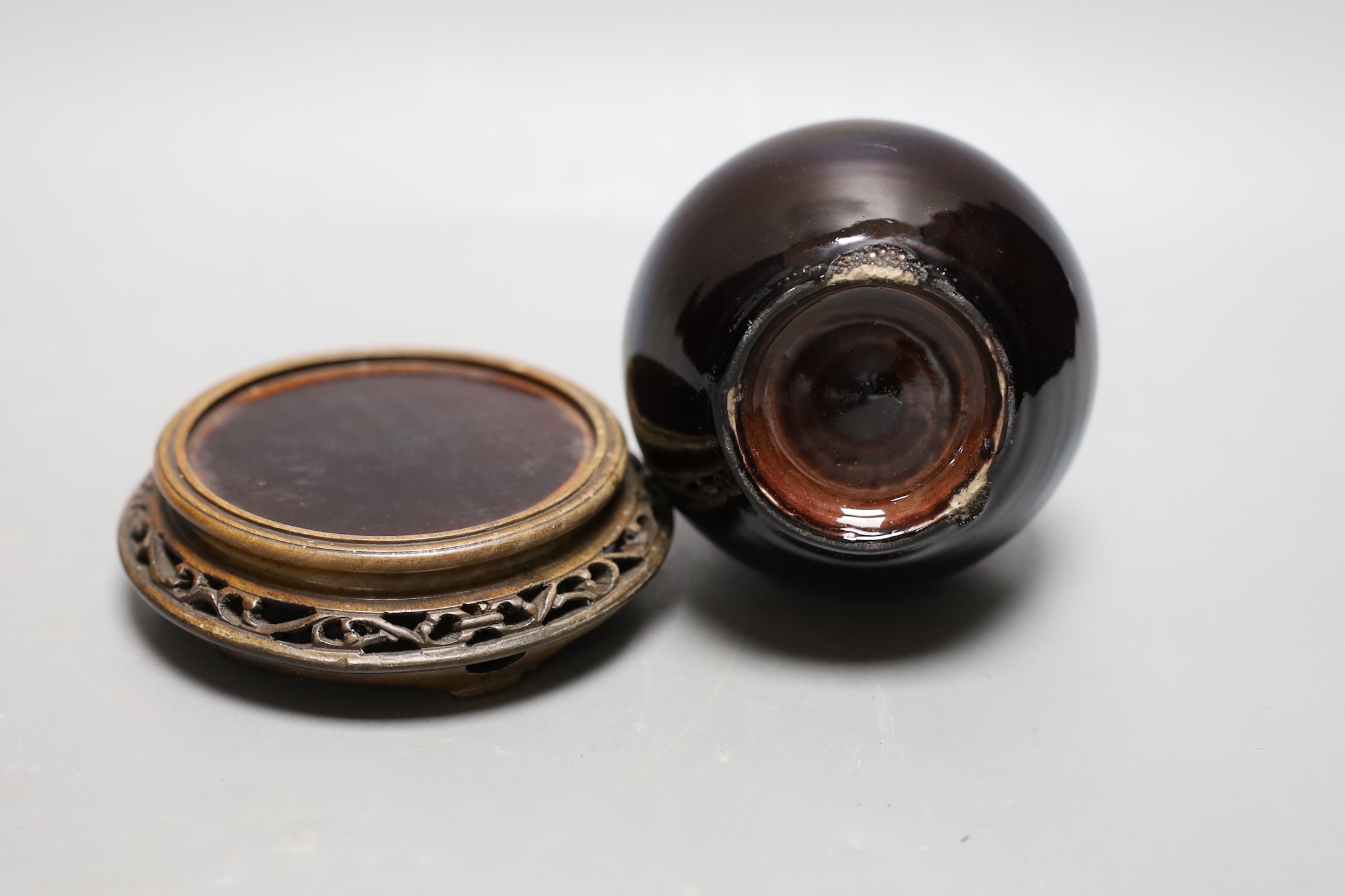A Chinese brown monochrome double gourd vase (on stand). 19cm tall